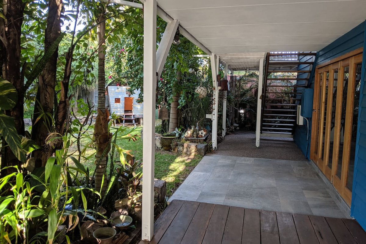 A sheltered tiled walkway runs beside Aaron's Beachside Boat House, linking the downstairs exterior doors with the staircase to the upper level.