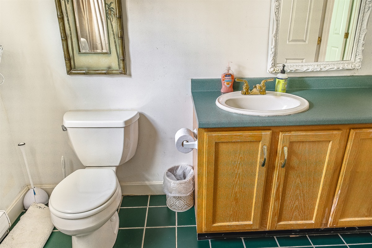 The guest bathroom features a large vanity with ample counter space for the whole group. Freshly stocked with quality hand soaps and featuring charming gold fixtures, it’s a bright and functional space designed for a smooth morning routine.