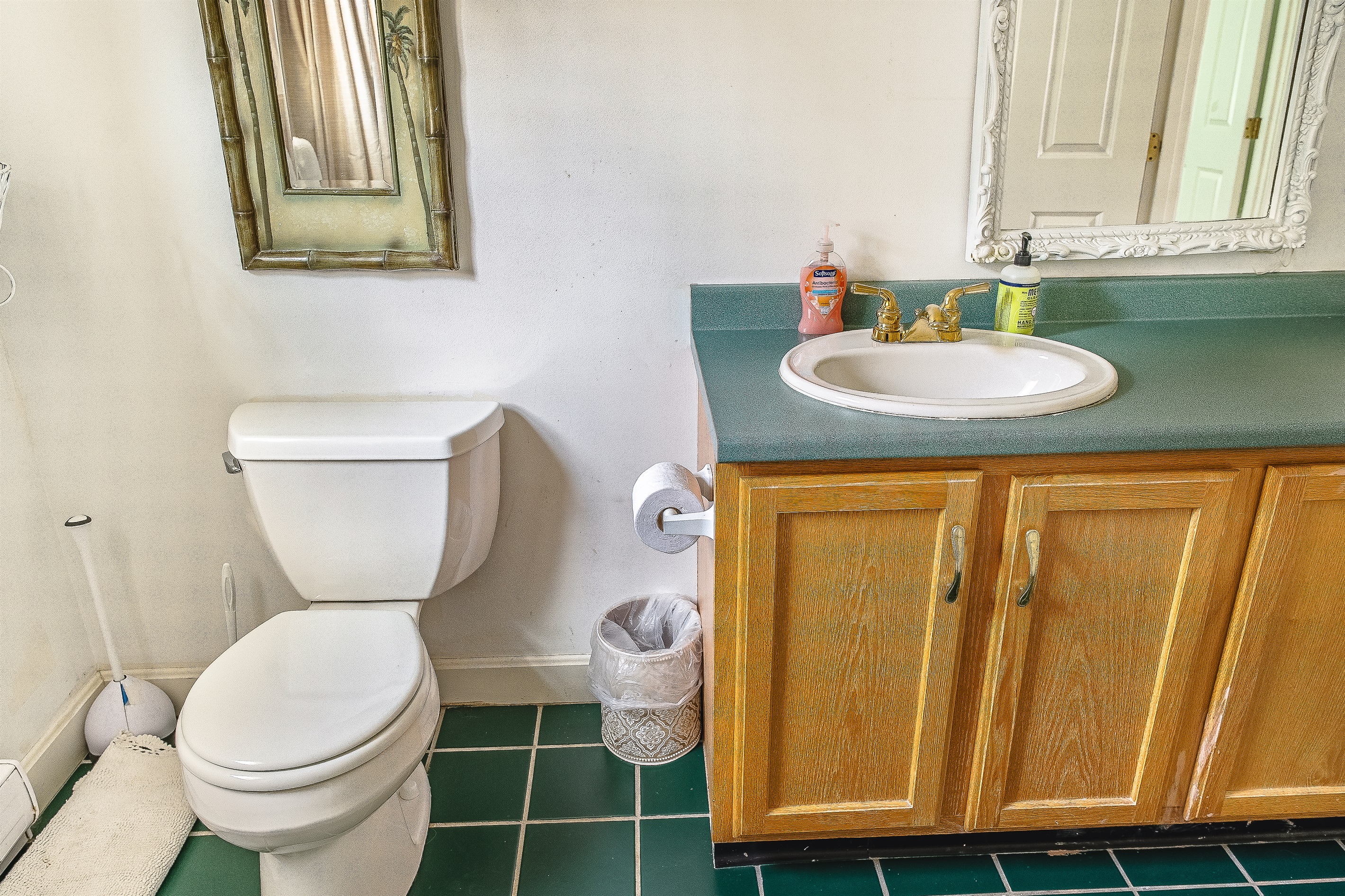 The guest bathroom features a large vanity with ample counter space for the whole group. Freshly stocked with quality hand soaps and featuring charming gold fixtures, it’s a bright and functional space designed for a smooth morning routine.