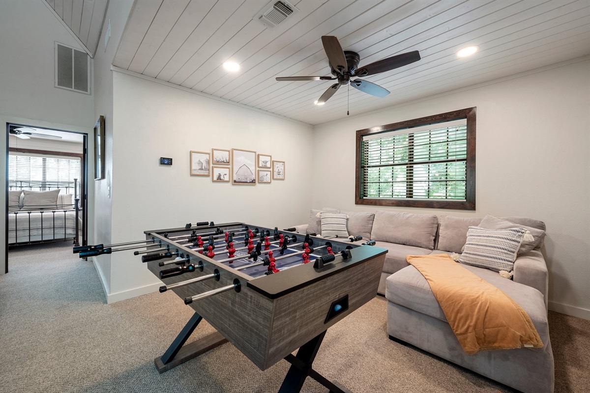 Upstairs loft with a sectional couch to longue and fooseball.