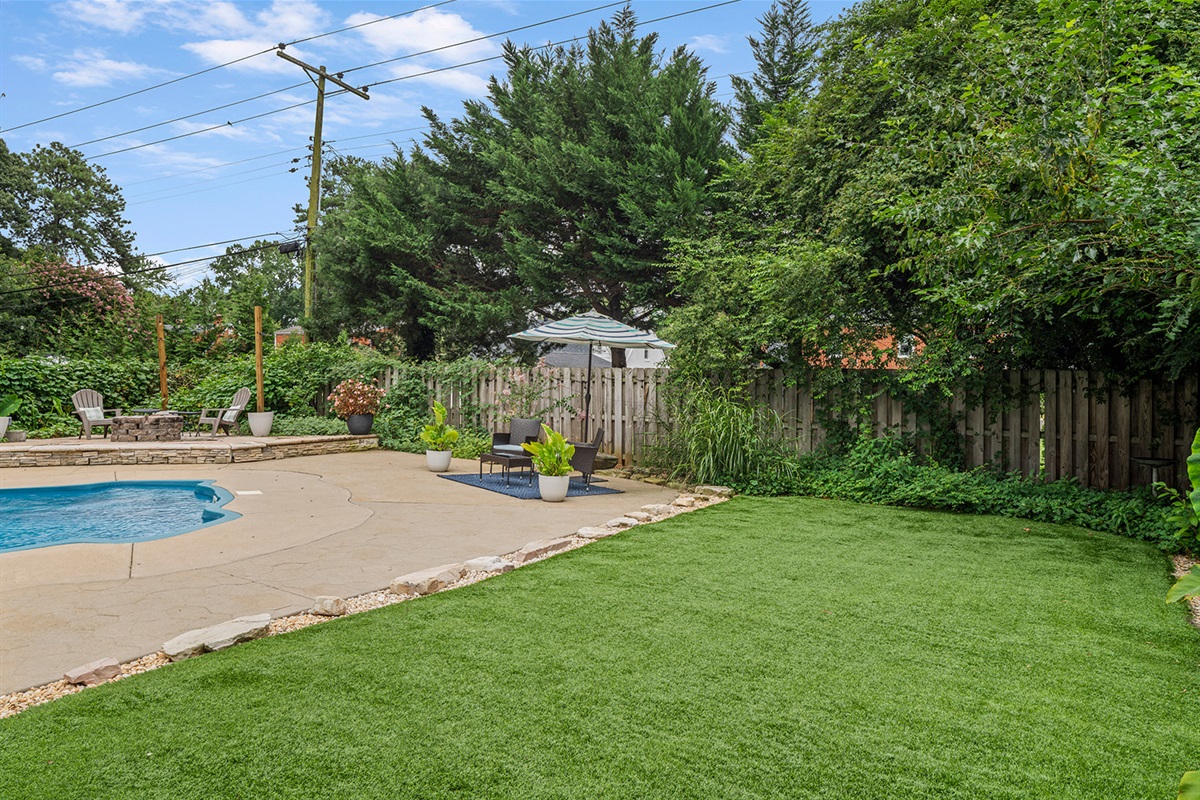 Outdoor Oasis: Dive into relaxation by the pool surrounded by lush greenery and chic seating!
