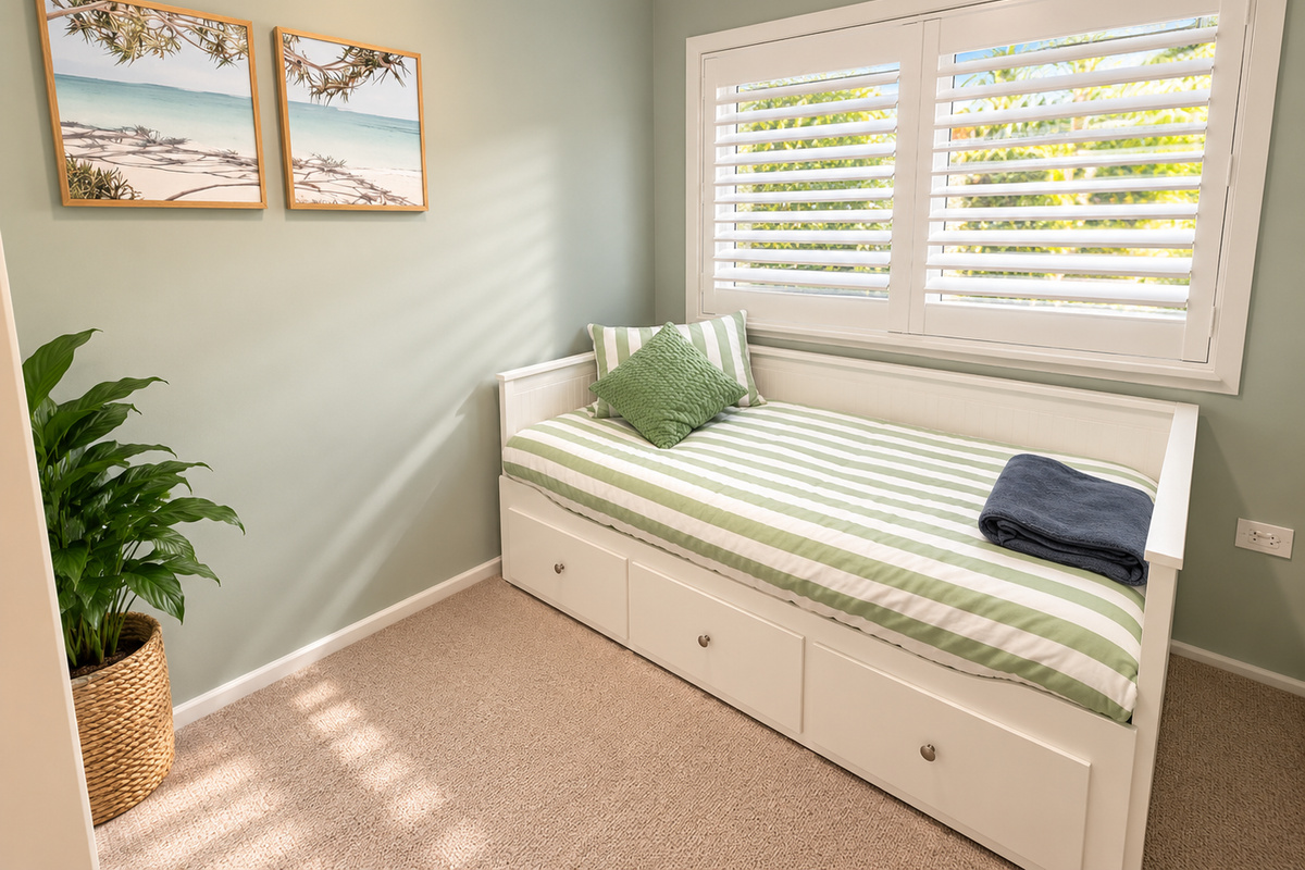 A bright and peaceful single bedroom featuring a comfortable daybed, fresh coastal styling and convenient built-in storage underneath.