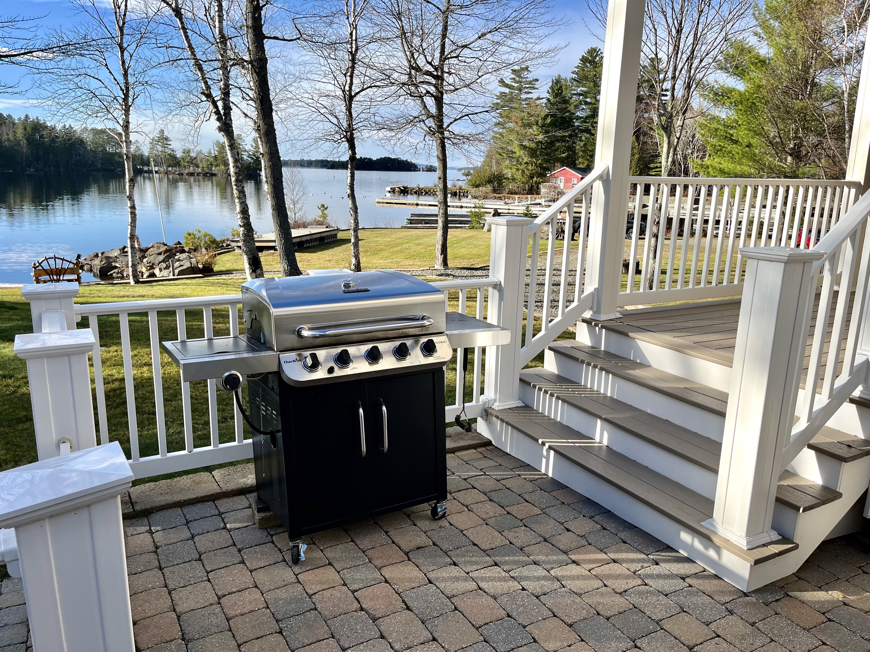 Paved patio with grill and lake views.