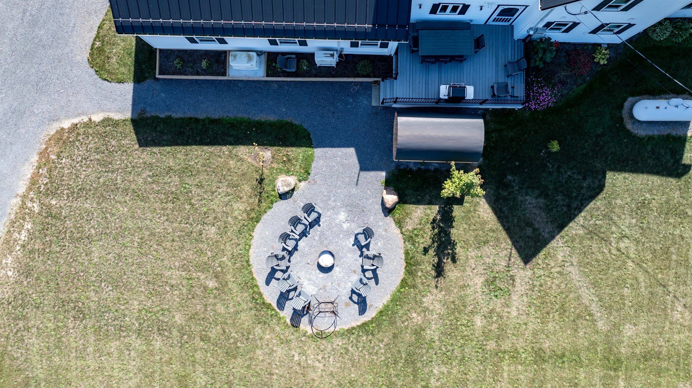 Bird’s-eye view of your private outdoor oasis — featuring a fire pit, dining area, and relaxing sauna retreat