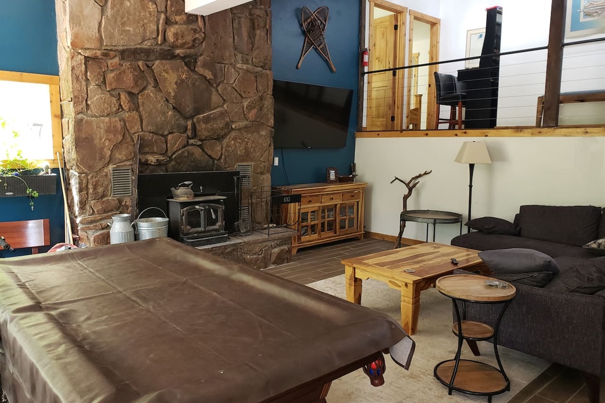 Main living room with 70" tv fireplace and pool table. 