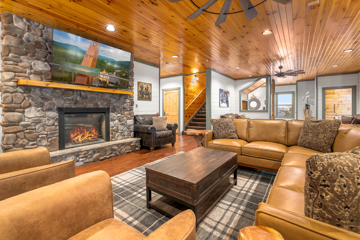 A 75" TV, roaring fireplace, and oversized Italian leather sectional anchor the main living room — with multiple separate hangout zones so the full group never feels crowded into one corner. Two pull-out beds.
