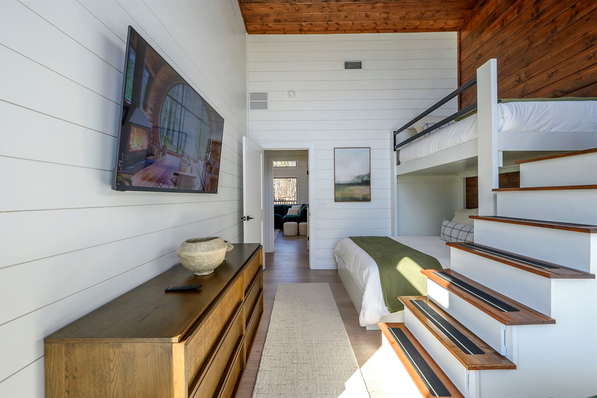 Bunk room with 2 bunk-bed units: 2 single/twin mattresses on top and 2 queen mattresses on the bottom (4 beds total). Sleeps 6. Cedar wood finishes, smart TV, and luxurious linens.