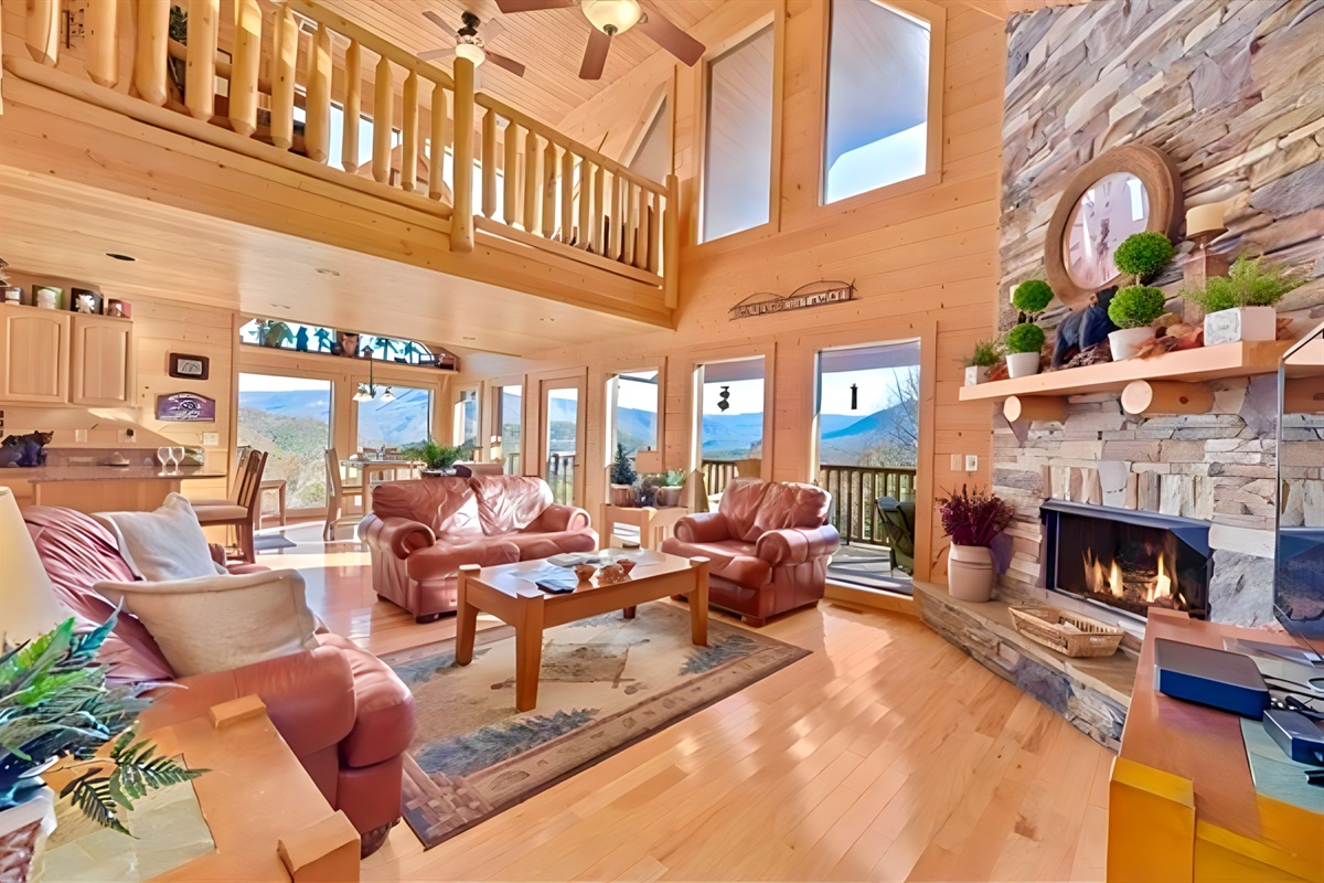 Gather in the heart of the cabin, where floor-to-ceiling windows frame the mountains like a masterpiece and the fireplace glows with stories waiting to be told.