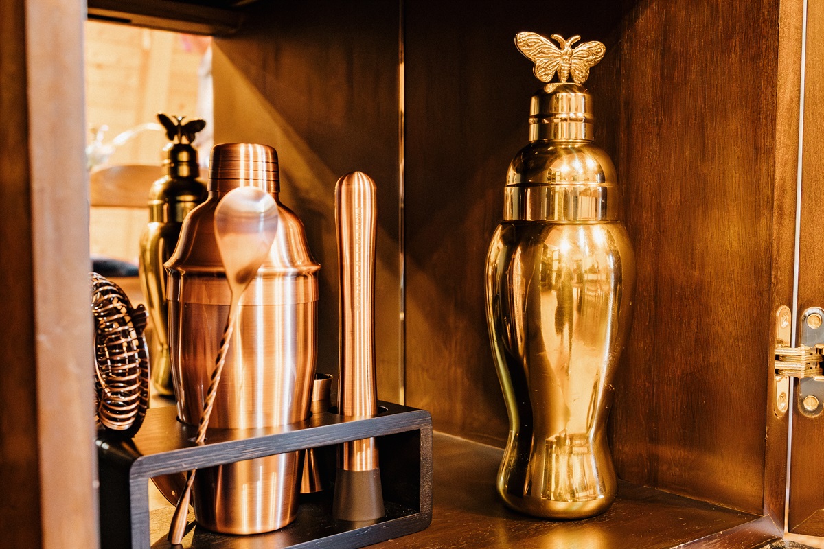 Golden hour light illuminates elegant barware at Poppywood Pines. This gothic western Show Low cabin features luxe touches for entertaining, perfect for crafting cocktails after exploring White Mountains hiking trails, fishing lakes, and outdoor adventures