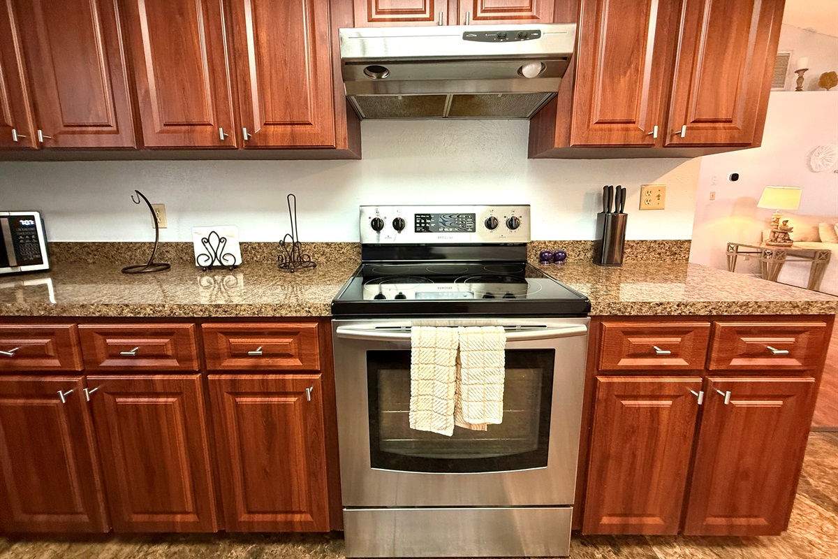 The kitchen is lined with deep cherry wood cabinets that provide a sense of warmth and elegance.