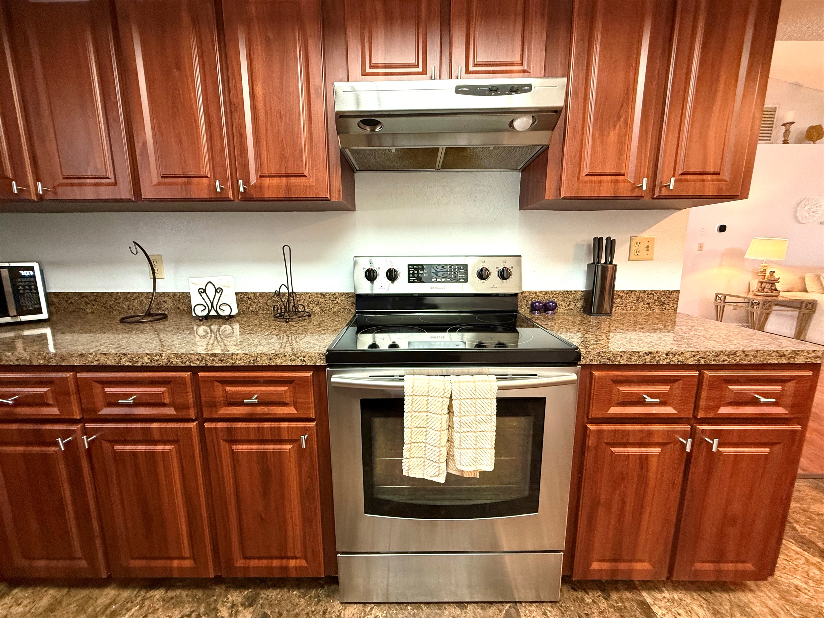 The kitchen is lined with deep cherry wood cabinets that provide a sense of warmth and elegance.