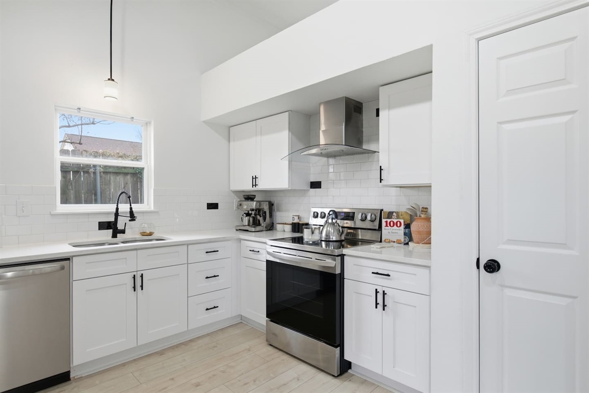 Fully equipped kitchen with single oven, microwave, fridge, dishwasher, cookware, and plenty of counter space for shared meals.