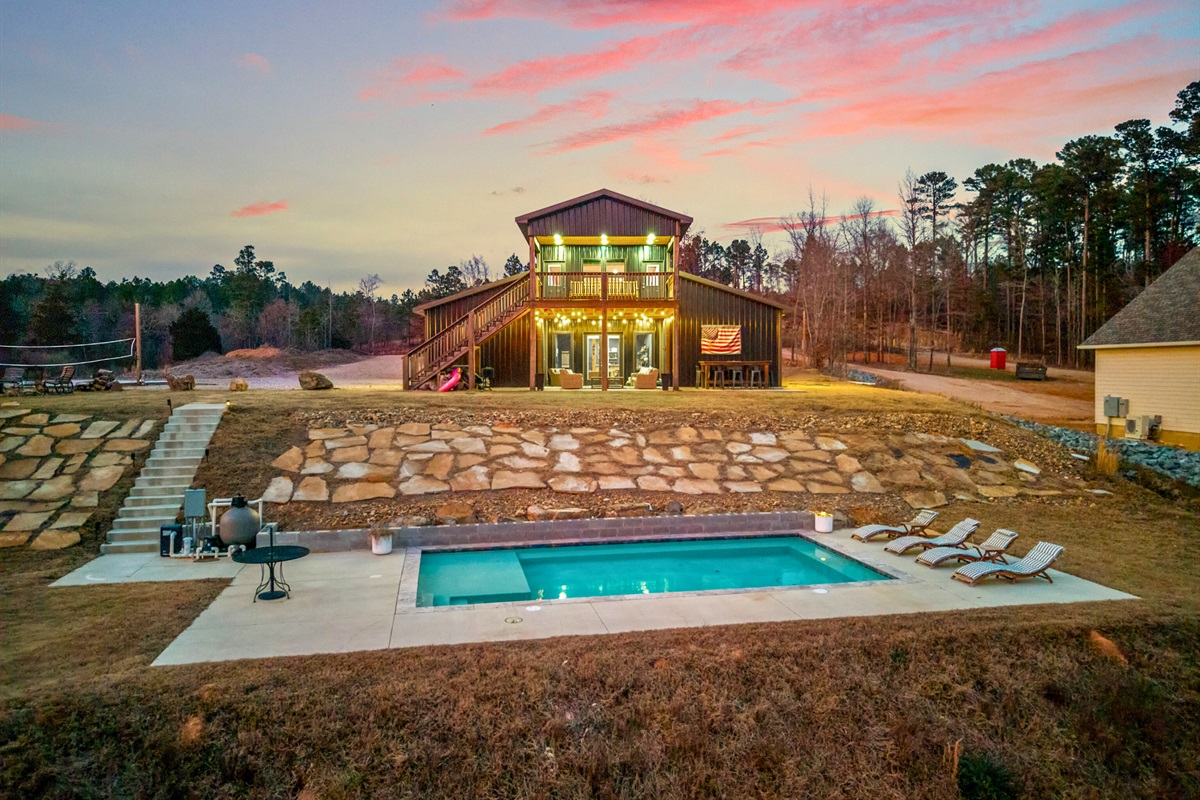 A stunning evening view of the property showcases how beautifully it lights up against the colorful sunset sky.