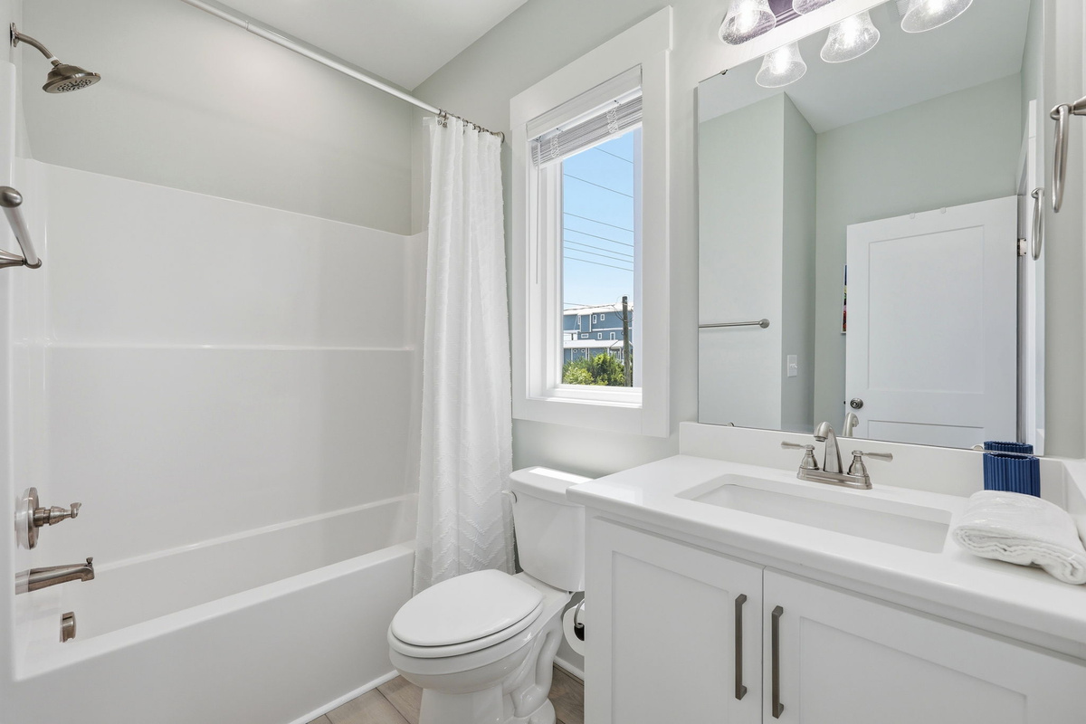 The nearby full bathroom features a tub and shower combination&mdash;perfect for families