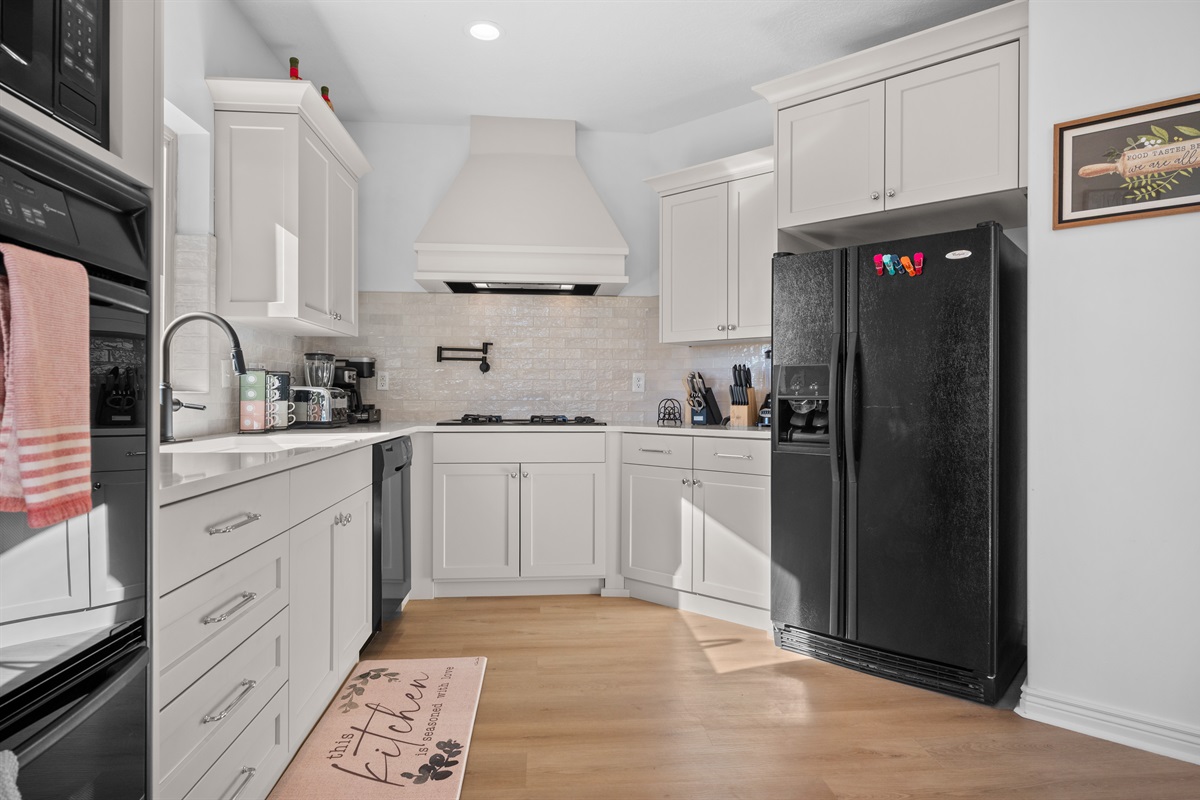 With its windows, quartz countertops, and stunning backsplash, the kitchen makes preparing dinner a truly enjoyable experience.