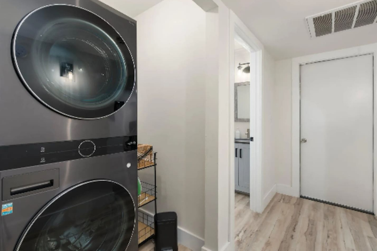 A stacked washer and dryer keep longer stays easy, tucked neatly just off the main hallway.