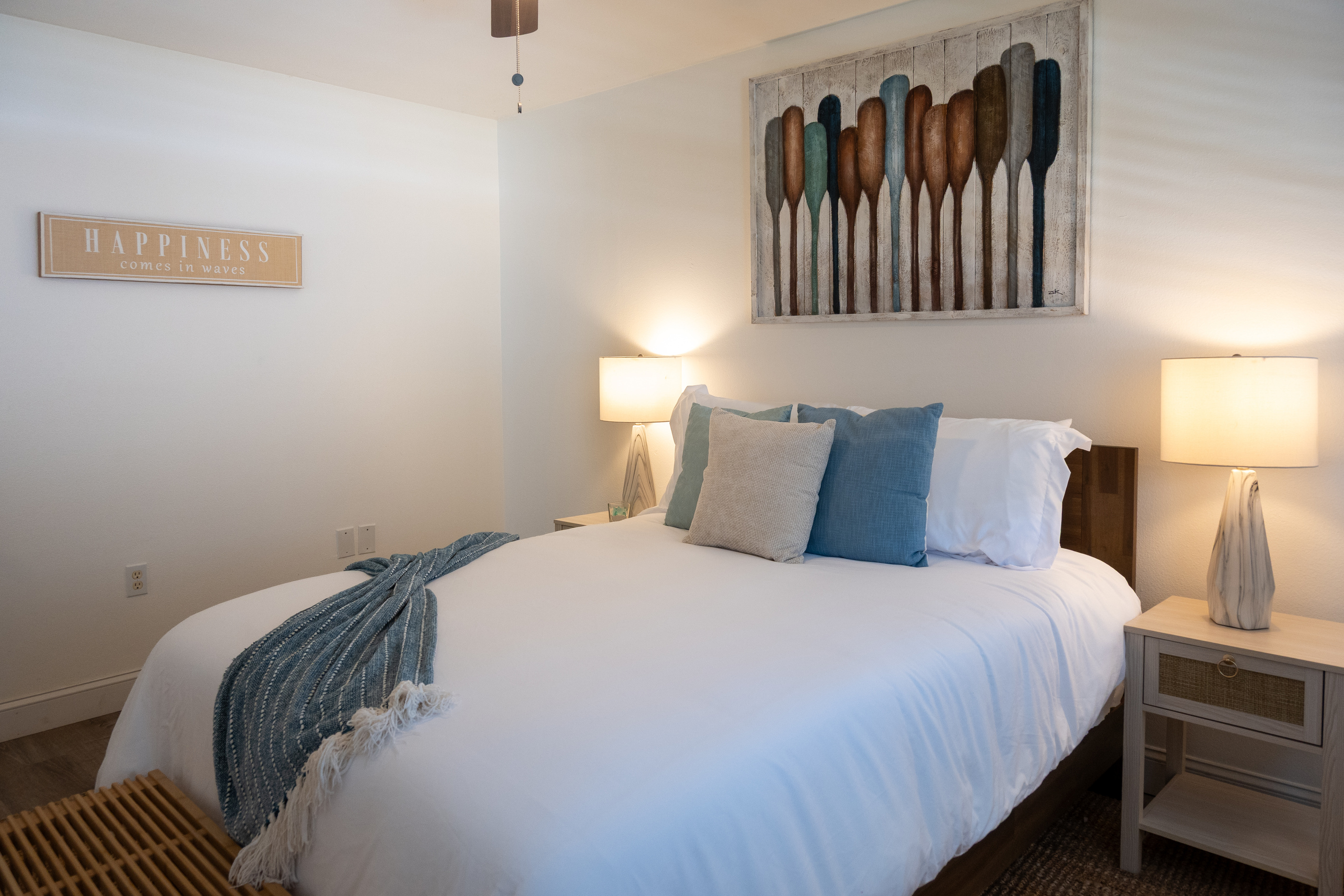 Palm House 2BR – Bedroom 1: plush queen bed under the oars – happiness is a beach day