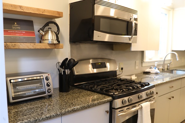 Kitchen from Dining Room showing toaster oven, tea kettle, stove, microwave,