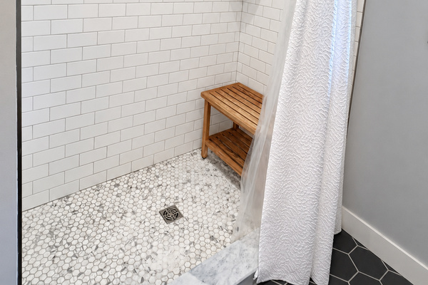 Tiled shower with bench.