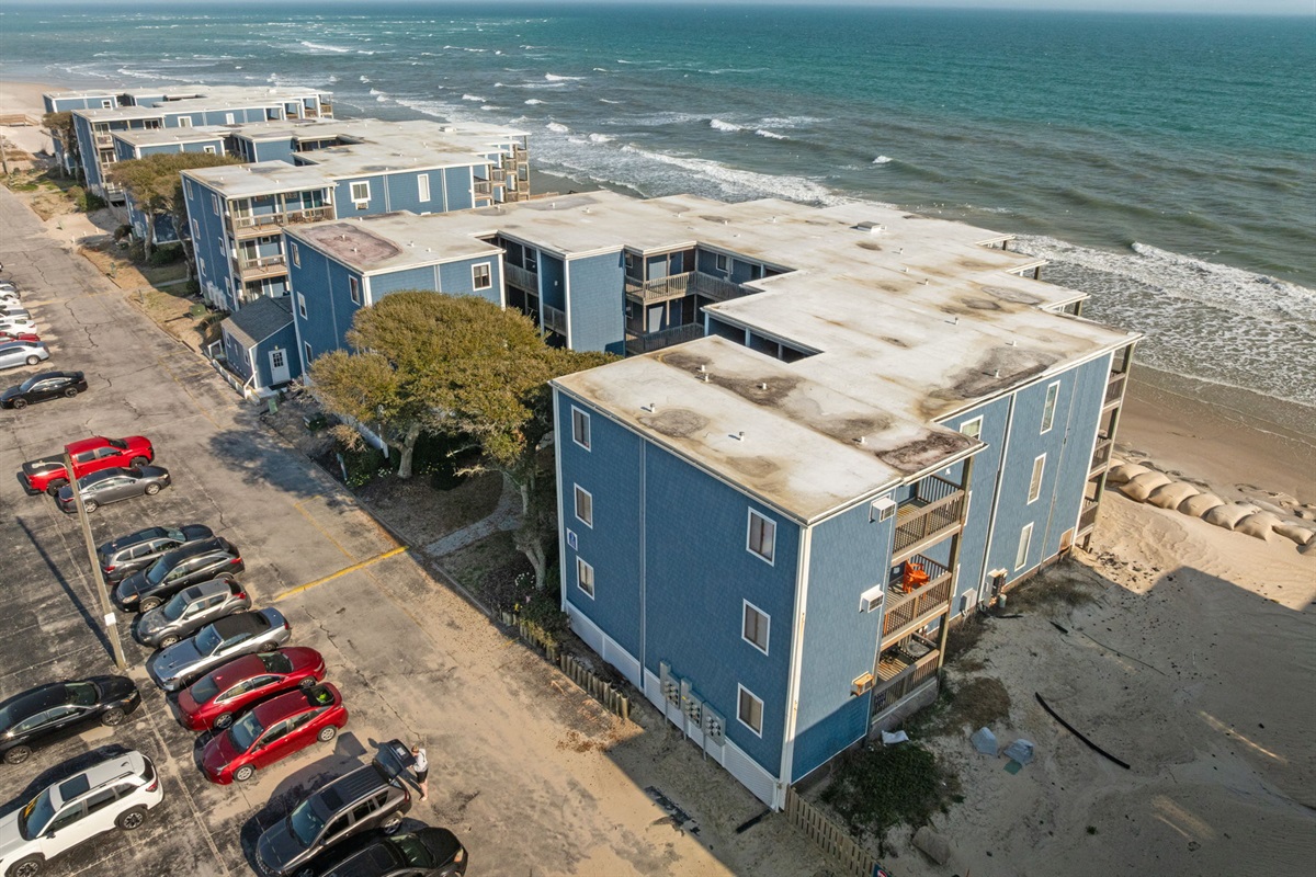 Wide aerial view of the beachfront buildings and surrounding coastal neighborhood