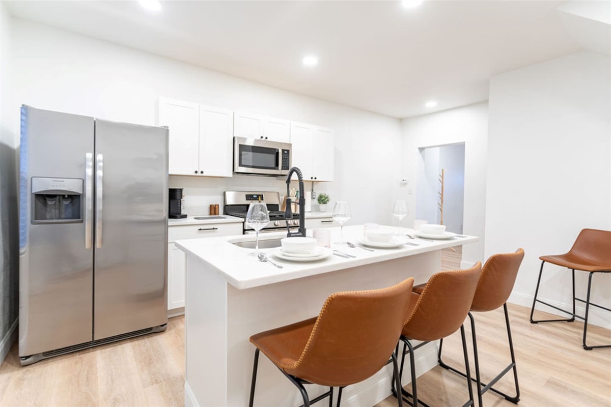 Fully equipped kitchen with sleek countertops and convenient dining space, ideal for cooking and enjoying meals at home.