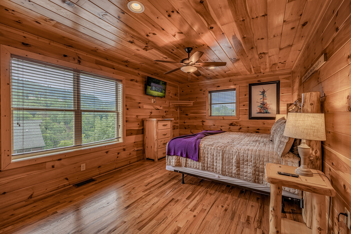The Acoustic Suite is an upper-level king retreat with warm wood, private en-suite bathroom access, and relaxed mountain-music character.