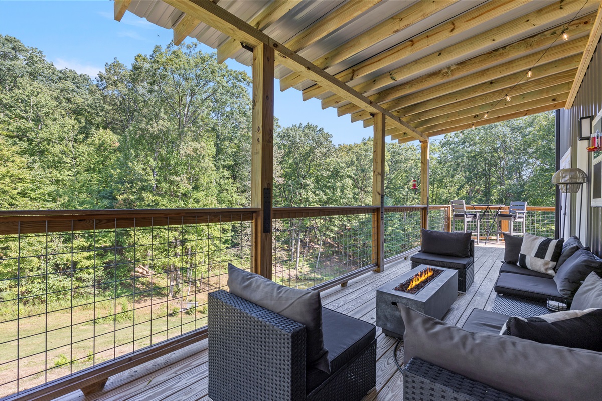 Spacious deck with comfy seating and peaceful wooded views — perfect for morning coffee or evening drinks.