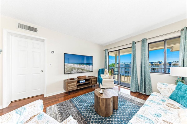 Comfortable living room with 65" smart TV and sleeper sofa.