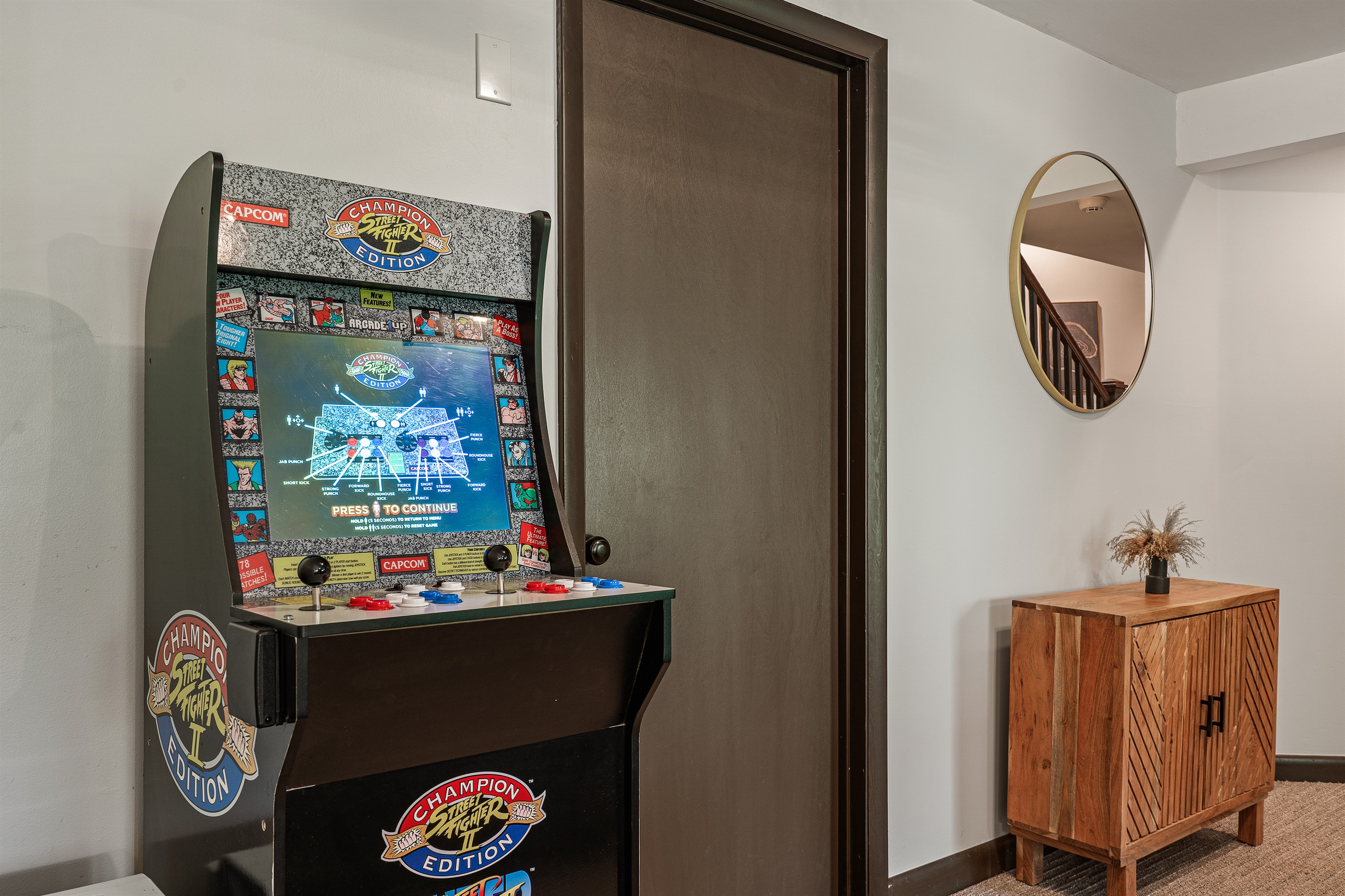 Unwind in the lower-level living room, equipped with a TV and cozy seating for movie nights or game days.