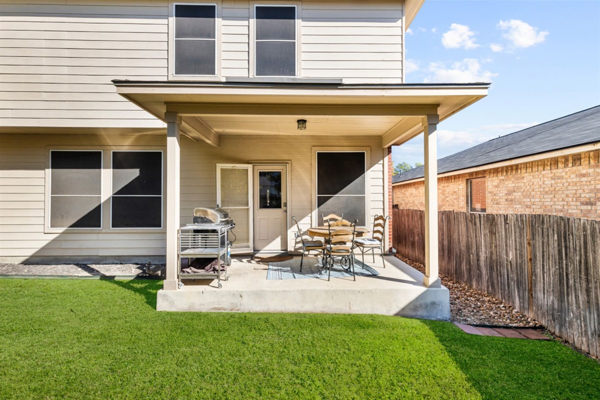 Private backyard with gas grill, BBQ utensils, and an inviting outdoor setup for grilling, gathering, and enjoying the fresh air.