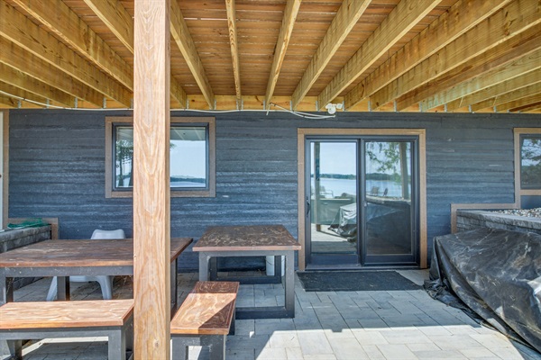 Shaded lower-level patio with picnic tables—great for outdoor meals and relaxing after a day on the lake