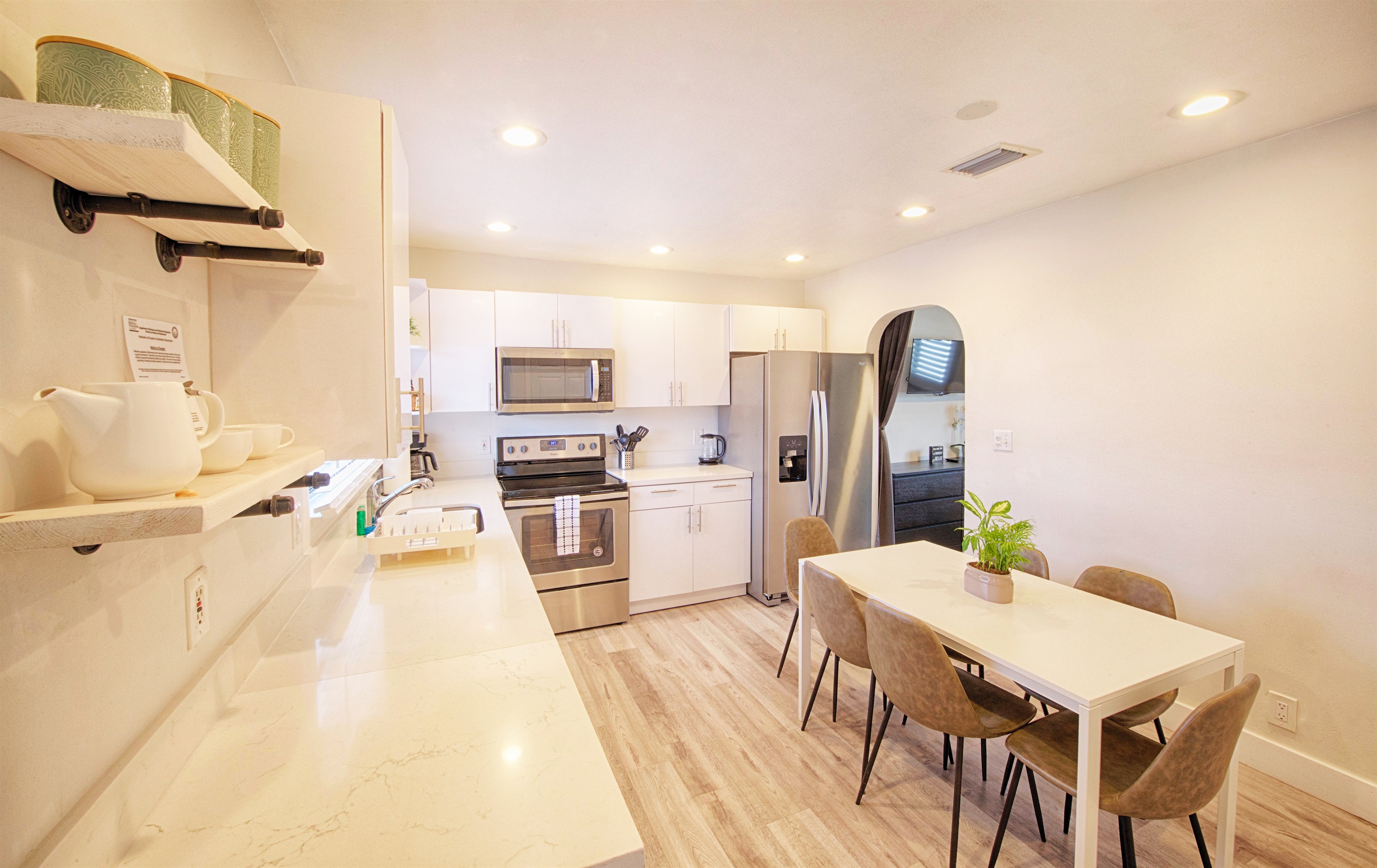 White quartz countertops throughout with dining table. 5m video tour includes open cabinets to show supplies.