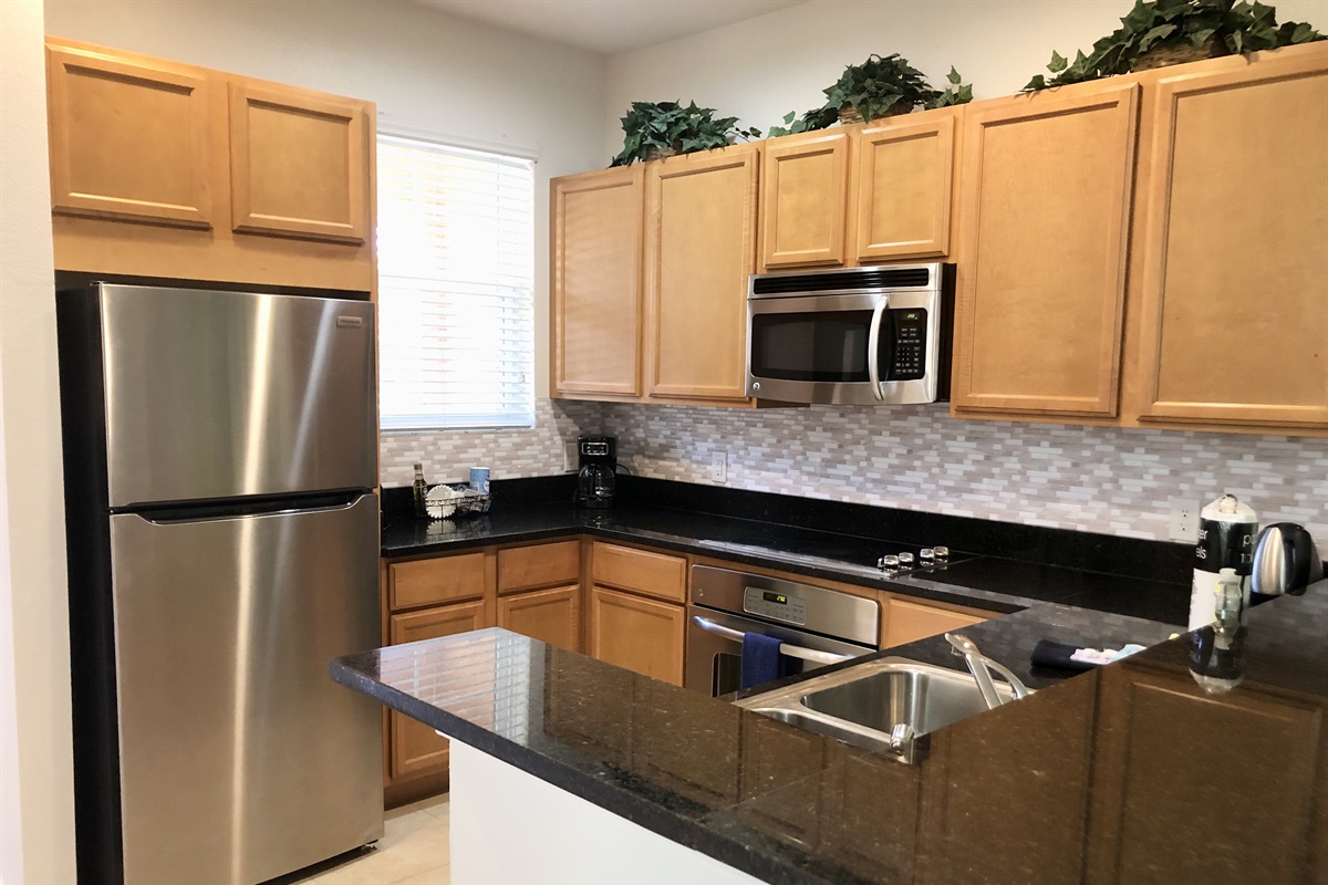 Spacious kitchen with stainless appliances and solid surface countertops