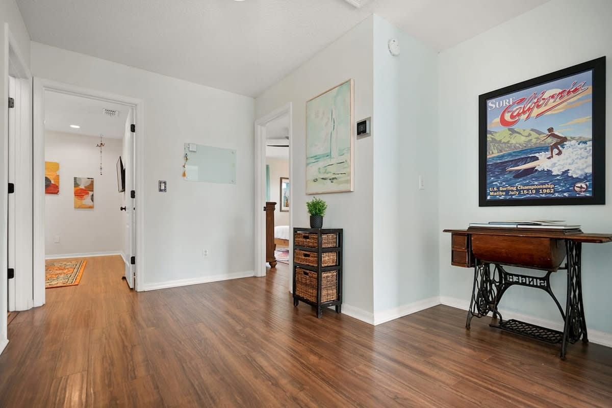 The upstairs hallway linking the bedrooms, the guest bathroom and the laundry room. Four bedrooms and three and a half bathrooms across two floors, arranged so ten people never feel on top of one another.