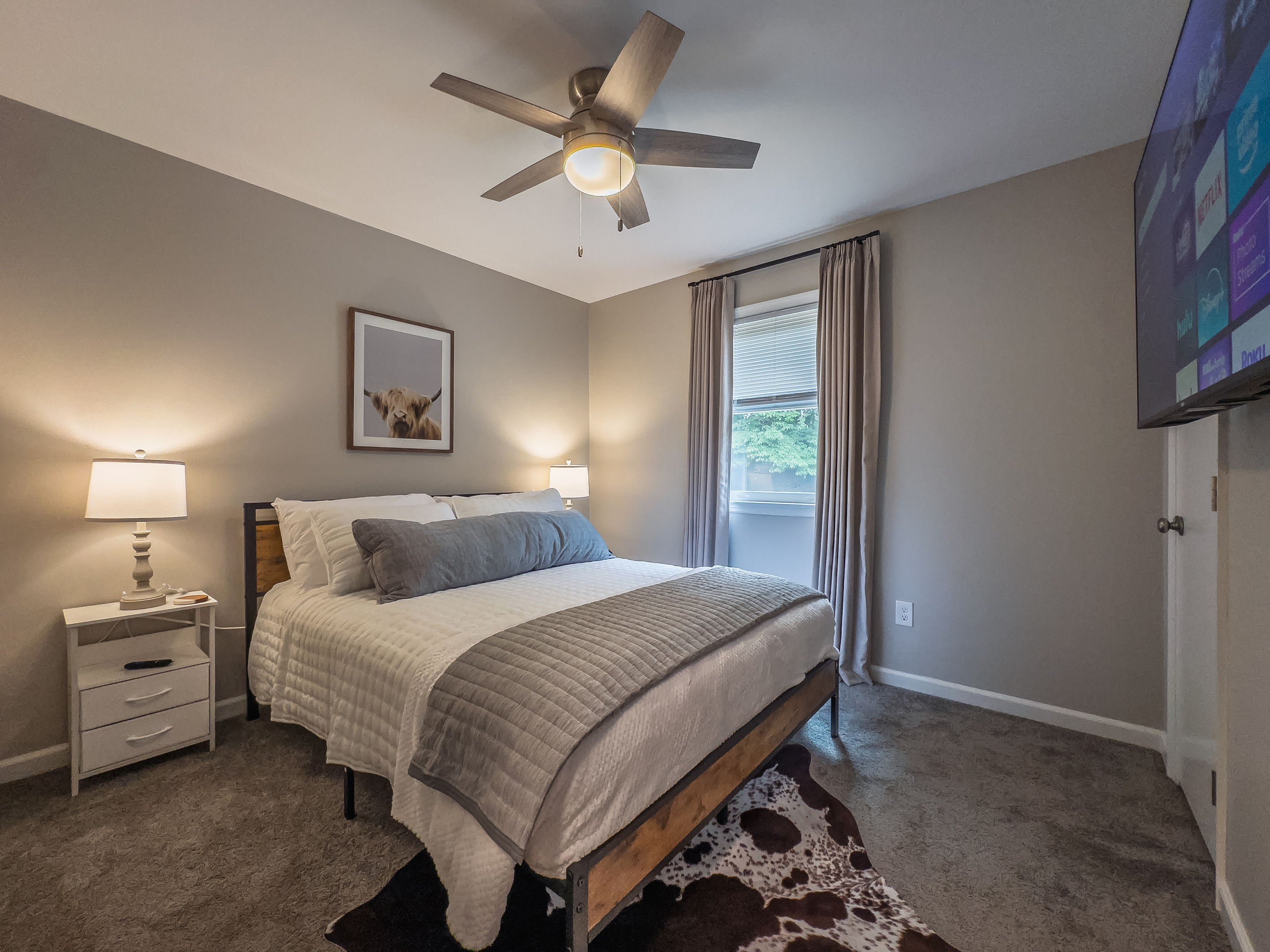 Queen bed, 55" Smart TV, ceiling fan, two led-light nightstands with multiple charging ports, two multi-light function lamps, blackout curtains, and full closet.