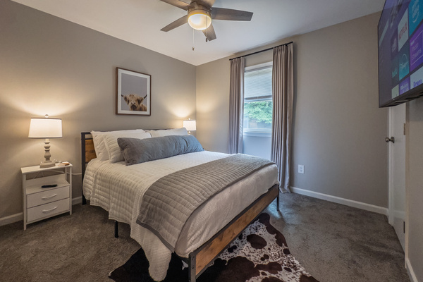 Queen bed, 55" Smart TV, ceiling fan, two led-light nightstands with multiple charging ports, two multi-light function lamps, blackout curtains, and full closet.