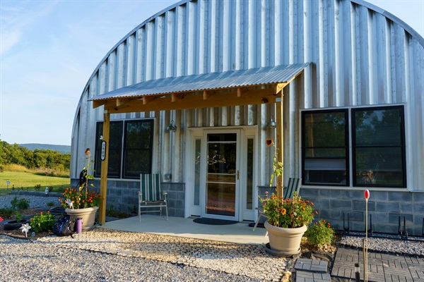Front porch with fall light & flowers, detailing stabilized gravel step-free entry. Parking for 4 vehicles. 