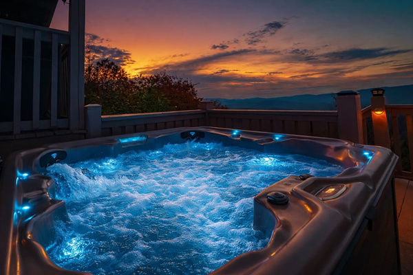 Blue-lit hot tub bubbling under a mountain sunset, Tanasi Lodge