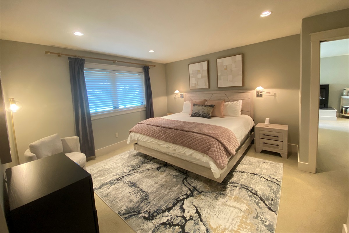 The larger primary bedroom with king-sized bed and ensuite bathroom invites you to rest and recharge.
