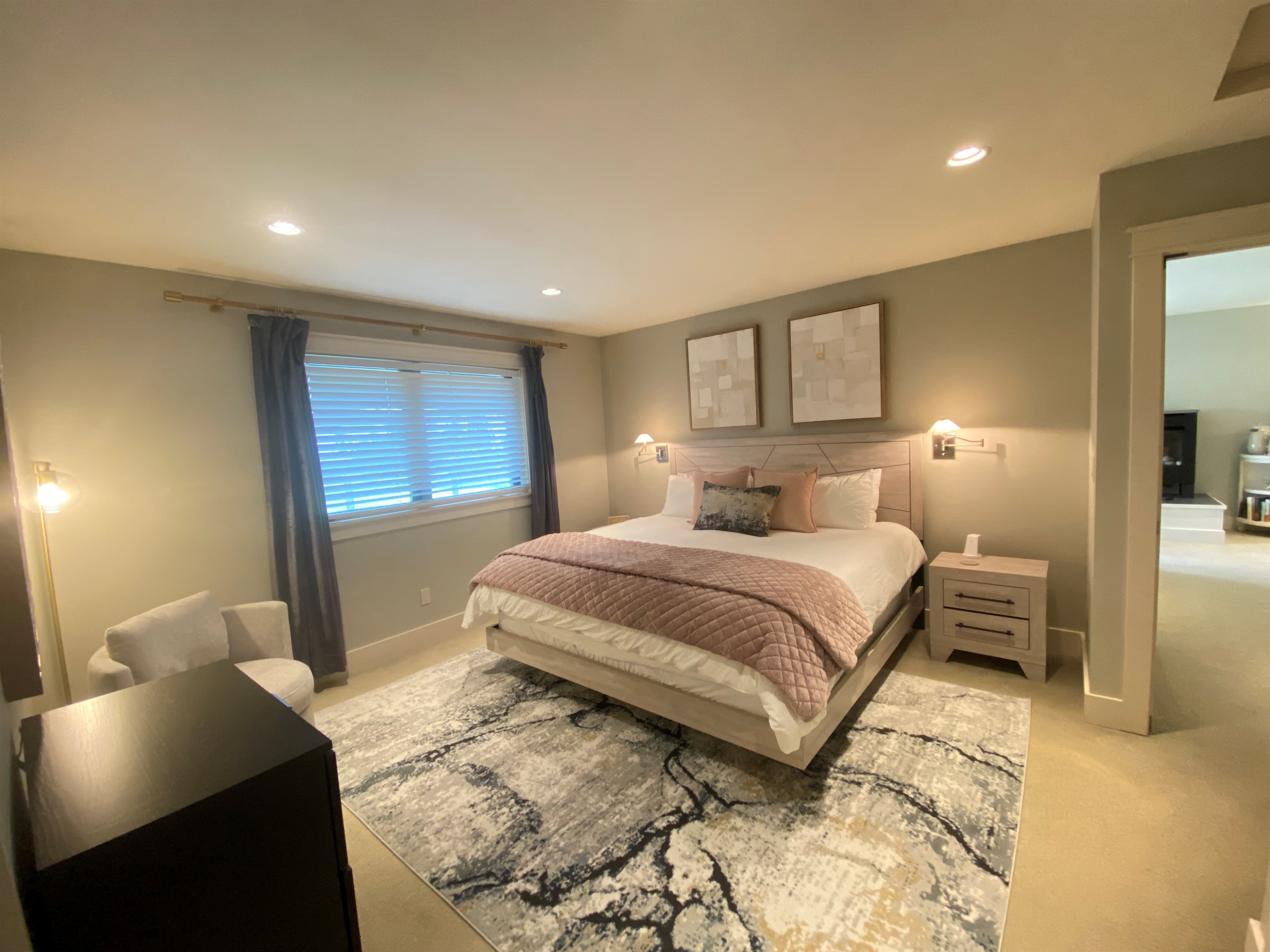 The larger primary bedroom with king-sized bed and ensuite bathroom invites you to rest and recharge.