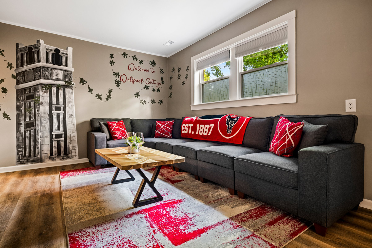 The Wolfpack living room features a hand-painted NC State mural of the Memorial Belltower.