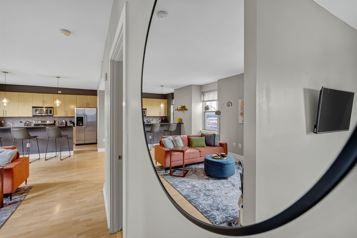 Step into style!  This playful mirror view highlights the seamless flow from bedroom to living area. Modern decor, open layout, and natural light create the perfect space to relax, work, or entertain.