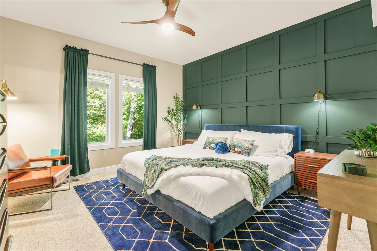 Statement green, mid-century warmth, and a luxe king bed set the tone in this moody primary suite. With a private ensuite and forest views, comfort runs deep
