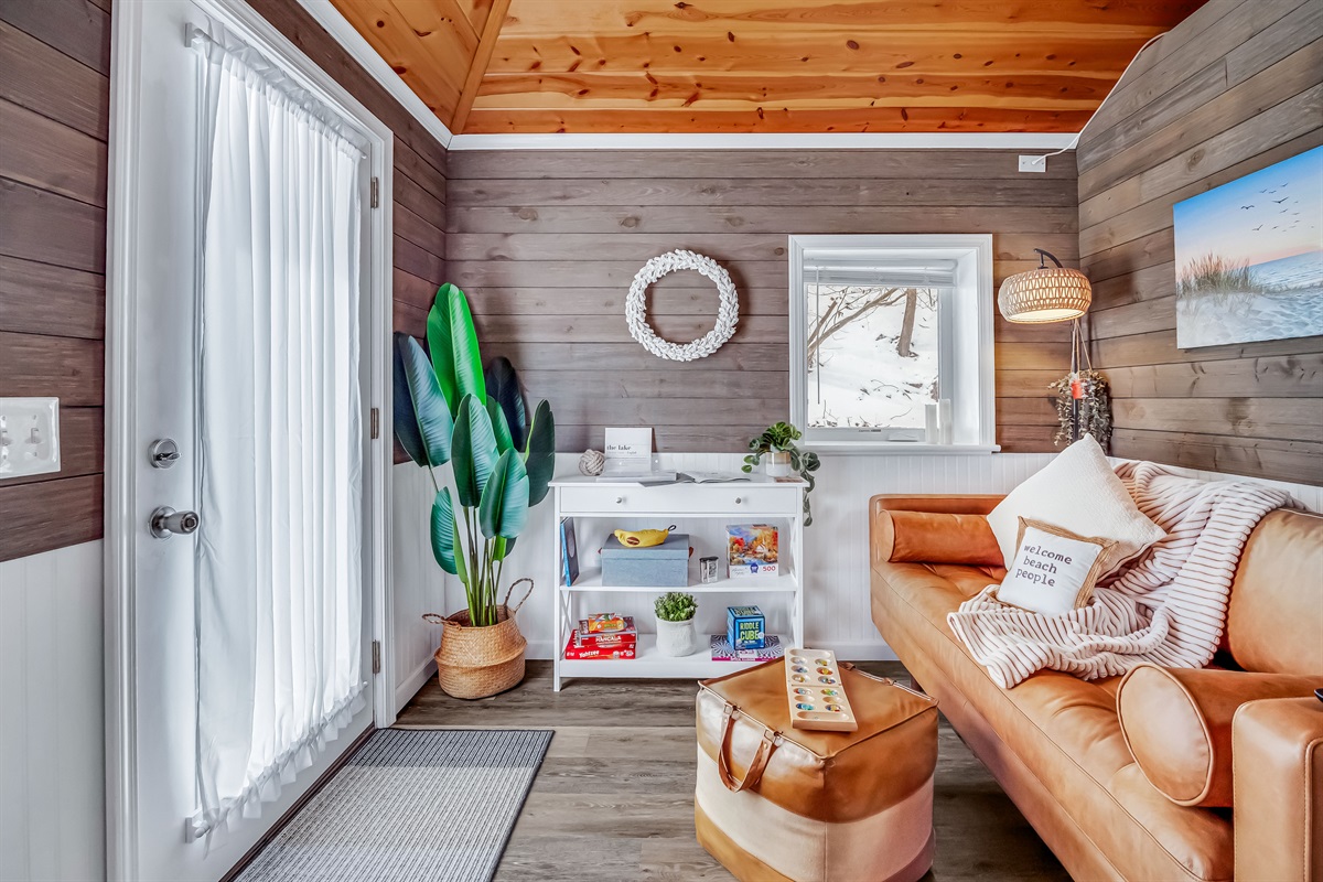 Duet Cottage - The living room offers a comfortable leather sofa and a curated selection of games, ideal for relaxing and enjoying quality time together.