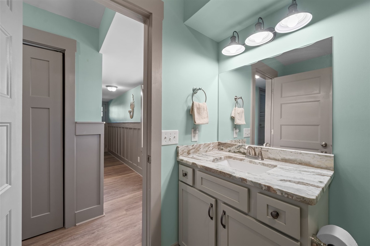 1st floor bathroom featuring a stone-top vanity, ample counter space, and easy access from the main living areas for everyday convenience