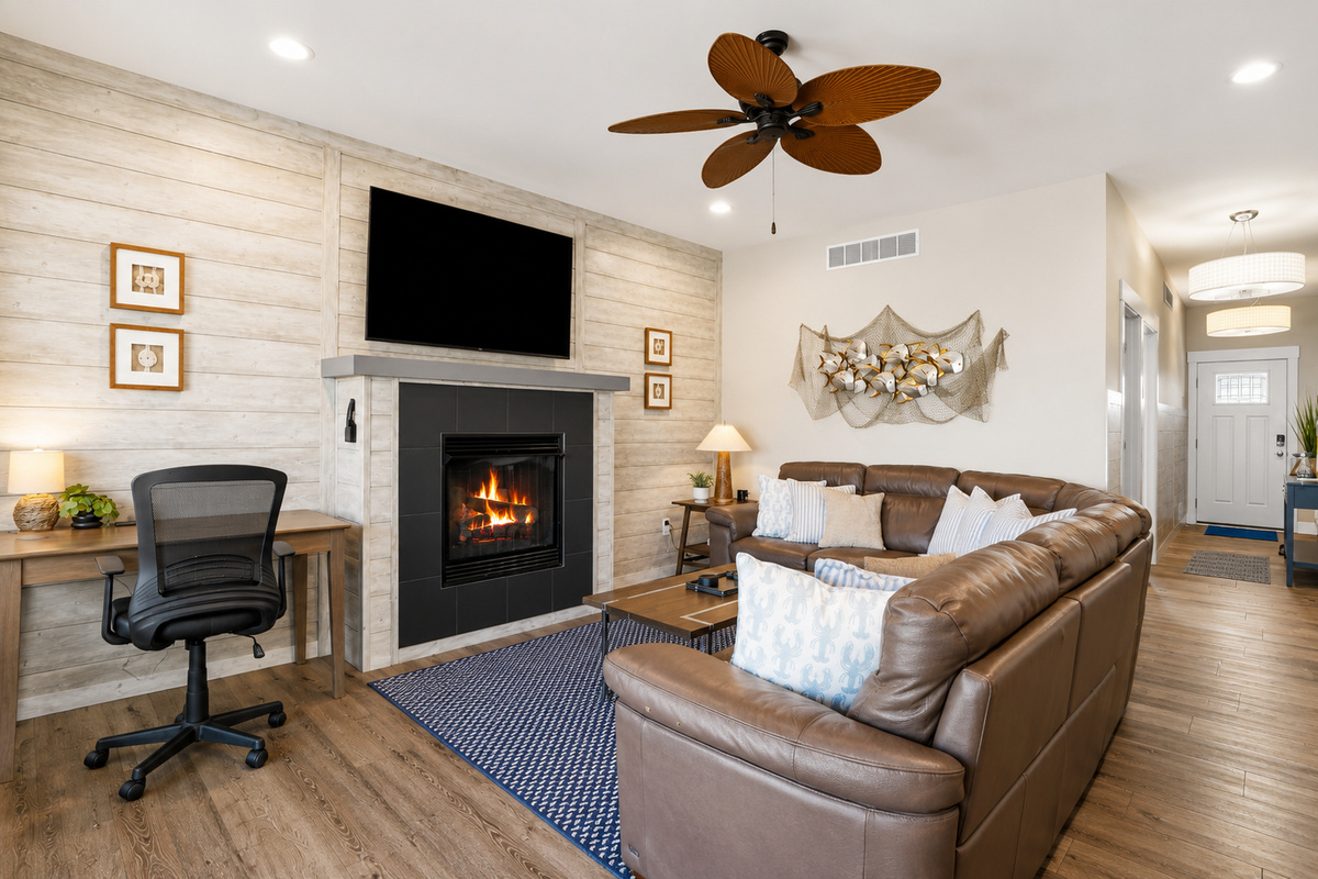 The heart of the home, this inviting living room combines modern coastal style with everyday comfort. Enjoy the cozy fireplace, spacious seating, and a convenient workspace—perfect for relaxing, reconnecting, or working remotely.