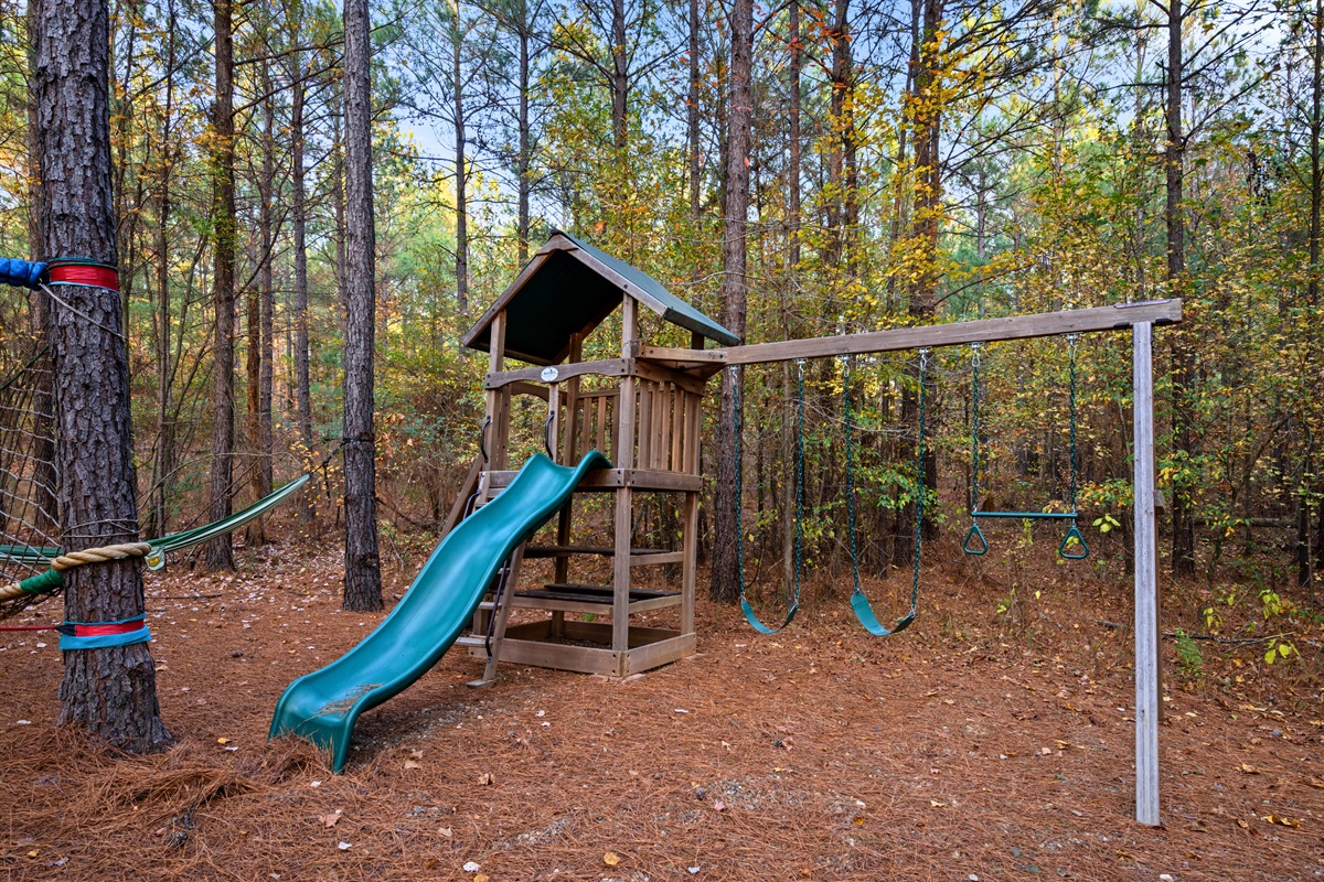 This classic wooden playset—with swings, a slide, and a little clubhouse—gives kids hours of entertainment under the tall pines.
