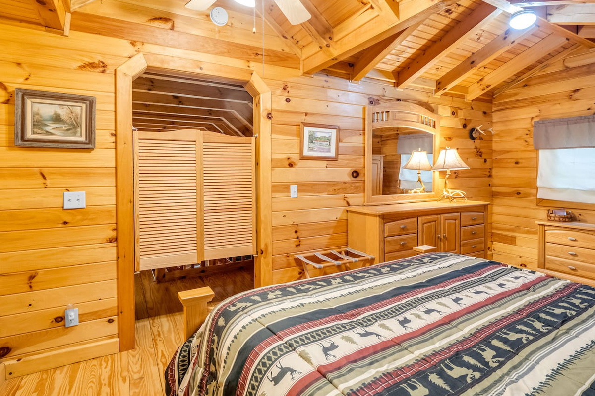 Third level bedroom featuring double bed, saloon doors, and plenty of storage space