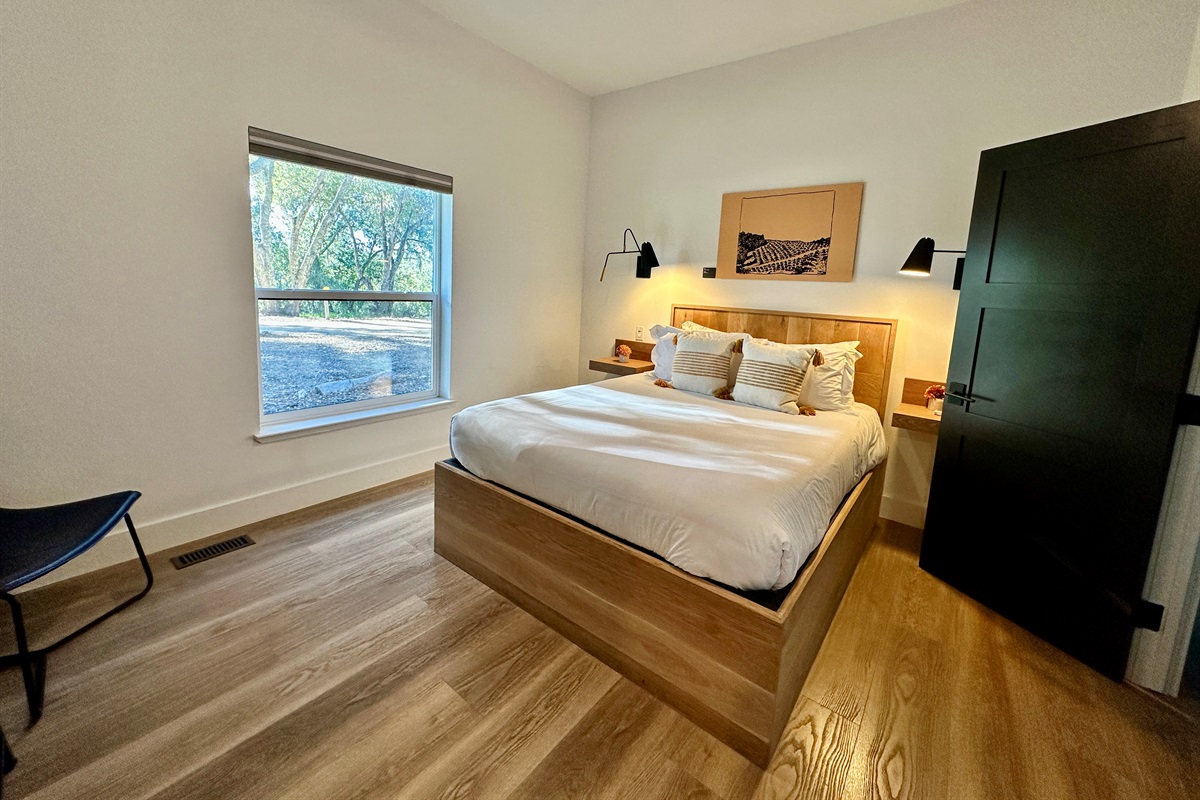 A plush, queen-sized retreat with a view anchored by a puffy mattress for an effortless stay.