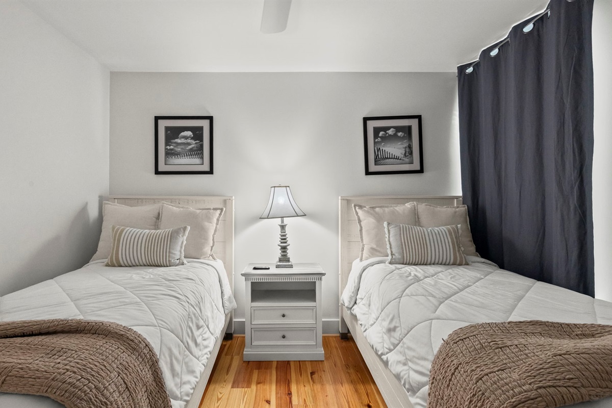 Your guests will feel right at home in the cozy guest bedroom of our Cotton Bayou condo, featuring twin beds, a smart TV for entertainment, and charming coastal decor. A perfect retreat for family or friends